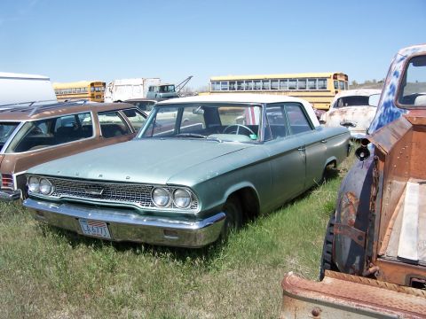 1968 Ford Coupe - Junkyard scene with a 1963 Ford Galaxie sedan and other vehicles under a clear sky.
