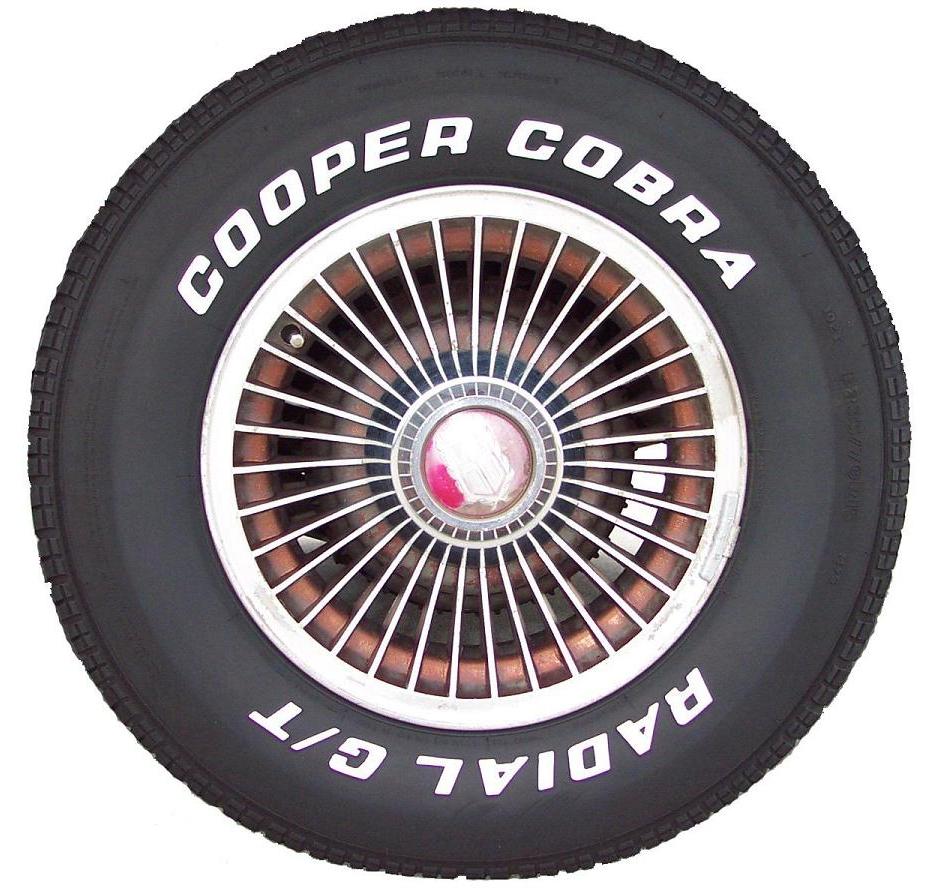 Cooper Cobra Radial G/T tire on a chrome wire wheel with a red center cap