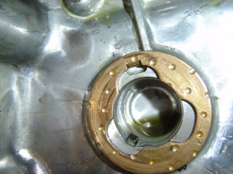 1992 Ford Bronco - Engine part detail showing a brass ring and internal mechanism with oil residue.