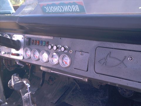 1990 Ford Bronco - Custom bare-metal dash panel in an early Bronco-style interior, fitted with five Auto Meter gauges including a voltmeter, a row of labeled…