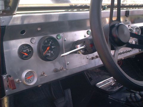 1990 Ford Bronco - Driver's-side view of a custom brushed-aluminum dash panel with a mechanical speedometer reading 37,022 miles, a black-face fuel gauge and…