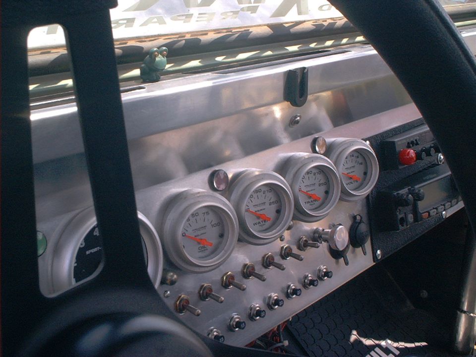 Aluminum dash with Auto Meter oil, water, trans and volt gauges over toggle switches
