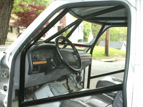1995 Ford Bronco - The interior of a truck is visible, a custom roll cage and dashboard.