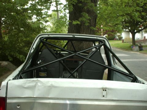 1995 Ford Bronco - Interior view of a white pickup truck modified with a black roll cage and racing seats.