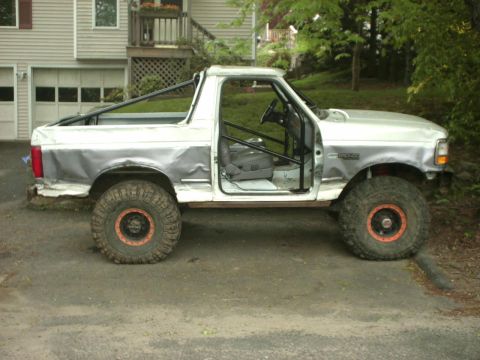 1995 Ford Bronco - This modified 1995 Ford Bronco features a roll cage and oversized tires, suggesting it's built for off-road use.