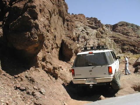 1997 Ford Ranger - White SUV navigates a rocky trail during the Calico Trip, showing its rear and off-road capabilities.