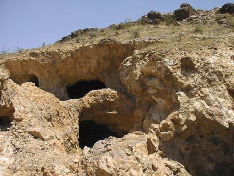 1997 Ford Ranger - Natural rock formation with multiple cave entrances on a dry, arid hillside.