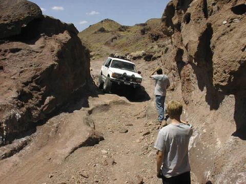 1997 Ford Ranger - Two people watch a white SUV drive through a , rocky canyon.