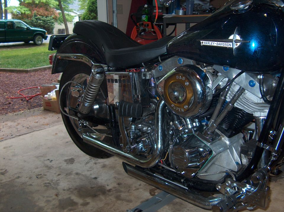 Black Harley-Davidson V-twin with S&S Super air cleaner and chrome exhaust in garage