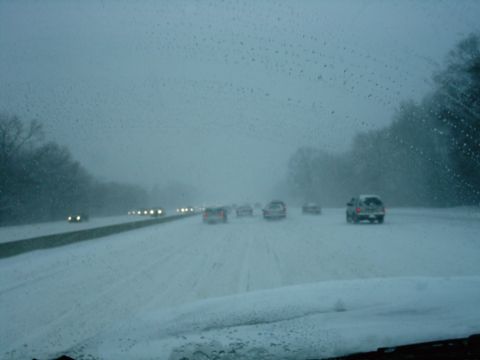 1989 Ford Bronco - Driving on a highway during a snowstorm with multiple vehicles ahead.