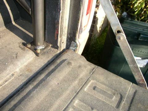 1995 Ford Bronco - Close-up view of a truck bed interior, with a metal pole and a trash bin visible in the background.
