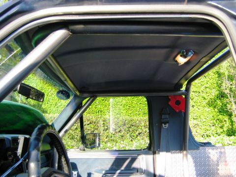 1985 Ford Bronco - The interior of a vehicle shows a custom roll cage installed around the cabin.
