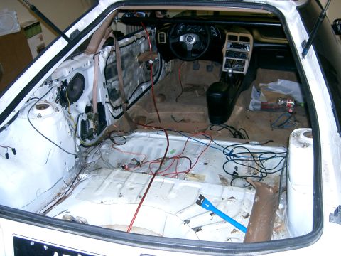 1996 Ford Probe - The interior of a car is shown with its door panels removed and wiring exposed, indicating it is undergoing repairs or modifications.