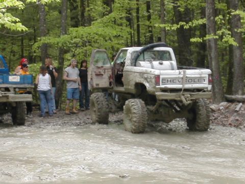 1979 Ford Bronco - A lifted, muddy Chevrolet pickup truck is seen from the rear during an off-road event.
