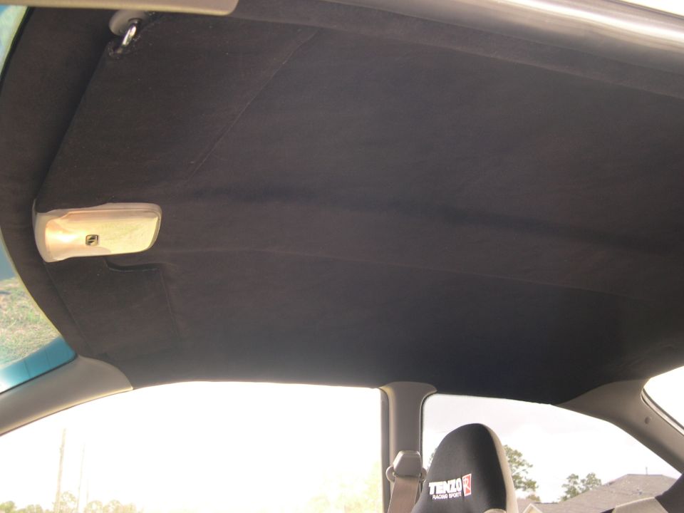 Car interior ceiling with a dome light and a racing seat visible. Text on seat reads 'TENZO SUPER MOTORS'