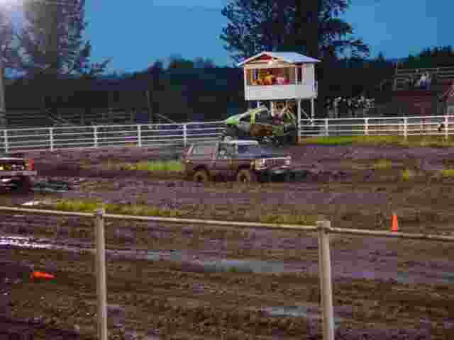 Trucks stuck in mud pit with a small observation booth in background