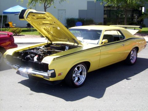 2002 Ford Mustang - A yellow 1970 Mercury Cougar XR7 is displayed with its hood open, revealing the engine bay.