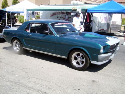 2002 Ford Mustang - A teal classic Ford Mustang is displayed at an outdoor event with tents in the background.