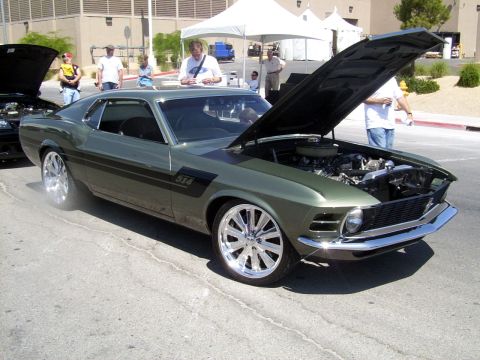 2002 Ford Mustang - A classic Mustang with its hood up is parked next to another Mustang at an outdoor event.