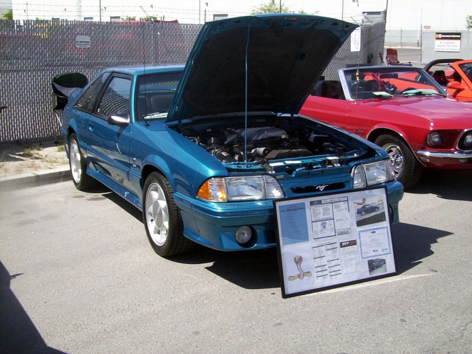 Teal 1993 Ford Mustang SVT Cobra coupe with hood open, display board in front