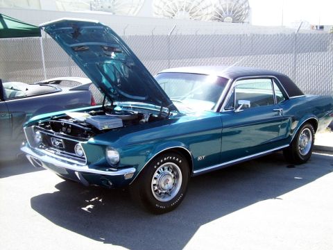 2002 Ford Mustang - Teal 1967-1968 Ford Mustang GT coupe, hood open, parked outdoors. Another vehicle is visible to the left.