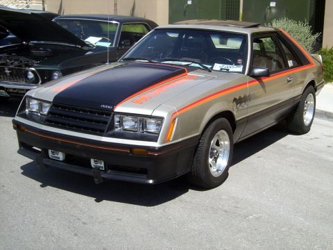 2002 Ford Mustang - This classic Ford Mustang features a distinctive two-tone paint scheme with bold orange racing stripes and a prominent hood scoop.