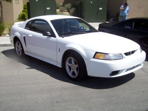 2002 Ford Mustang - White 2002 Ford Mustang parked outdoors with another vehicle behind it.