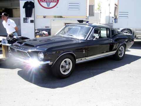 2002 Ford Mustang - A black 1967 Shelby GT350 is parked in front of a trailer with a Cobra logo.