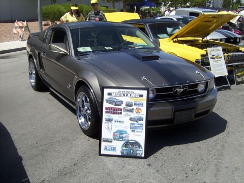 2002 Ford Mustang - A gray Ford Mustang is displayed at an outdoor event, with a yellow car and other vehicles visible in the background.