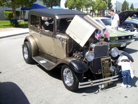 2002 Ford Mustang - A custom 1931 Ford Model A hot rod is displayed with its hood open, while a child examines the engine.