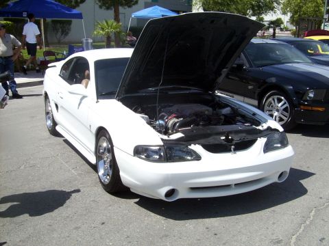 2002 Ford Mustang - A white 1994 Ford Mustang is displayed with its hood open, revealing the engine compartment.