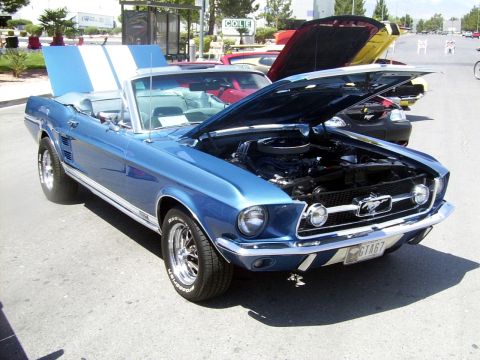 2002 Ford Mustang - A blue 1967 Ford Mustang convertible is displayed with its hood open, revealing the engine and racing stripes.