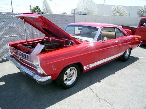 2002 Ford Mustang - A red classic car is parked with its hood open, revealing the engine bay. A GT badge is visible on the side.