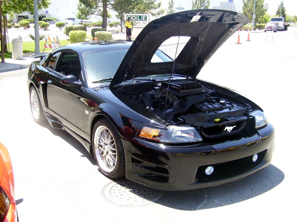 Black 2002 Ford Mustang front view with hood open, showing engine