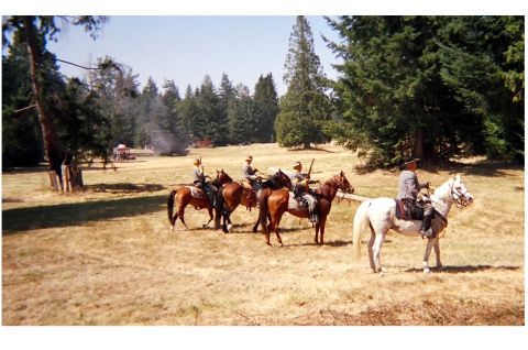 1996 Ford Bronco - Four individuals on horseback are depicted in an outdoor scene with a wooded area behind them.