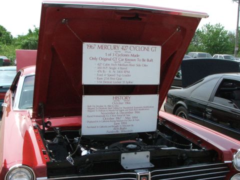 2005 Ford Mustang - A red 1967 Mercury 427 Cyclone GT is shown with its hood open, revealing the engine and two display boards detailing its history and specif…