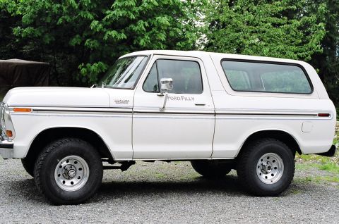 1979 Ford Bronco - This white Ford Bronco, identified as a 'Ford Filly' on the door, is shown from the side view.
