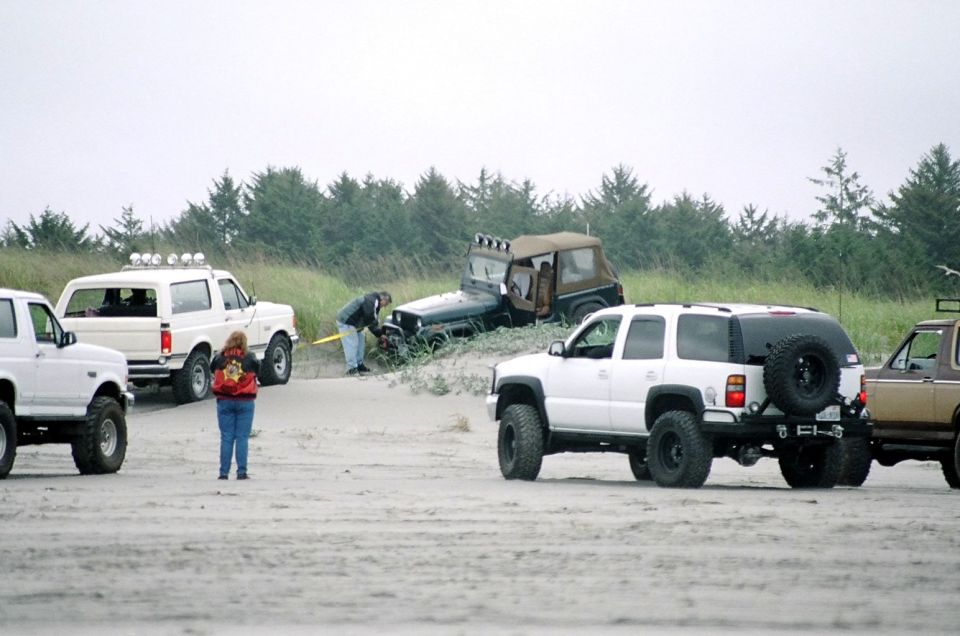 White Ford Bronco with off-road tires parked on a sandy beach