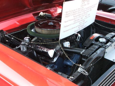 2005 Ford Mustang - The engine bay of a classic car is displayed with a detailed history placard, noting its build date in October 1965.