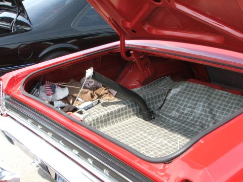2005 Ford Mustang - The interior of a red car's trunk is shown, with a black car partially visible in the background.