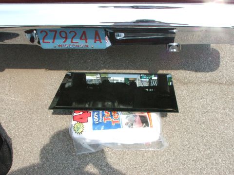 2005 Ford Mustang - Rear view of a vehicle bumper with a Wisconsin license plate and a piece of glass resting on a package of towels.