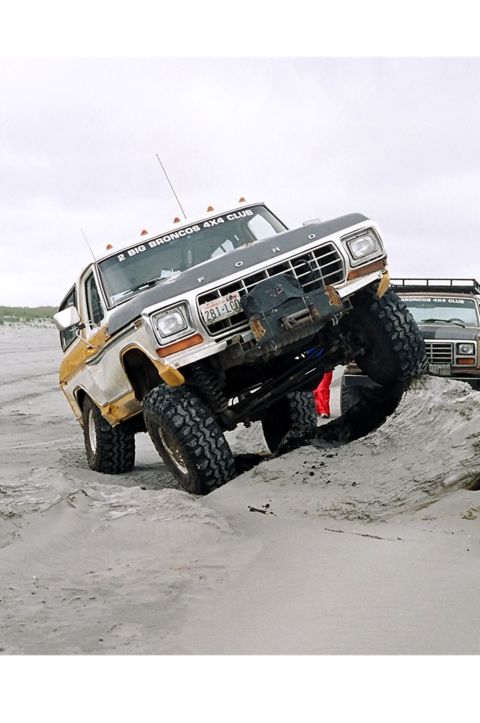 1979 Ford Bronco - This Ford Bronco is navigating a sandy terrain with another Bronco visible in the background.