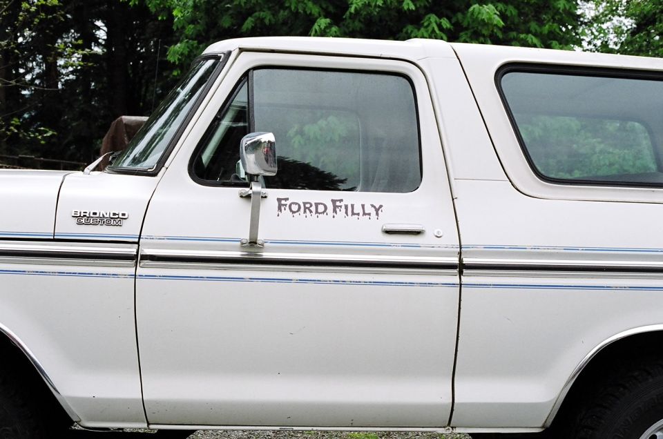 White Ford Bronco with 'Ford Filly' decal on the door and 'Bronco Custom' badge