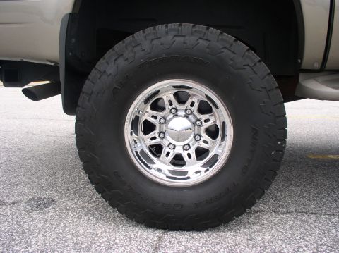 2000 Ford Excursion - Close-up of a large tire and chrome wheel on a lifted truck.
