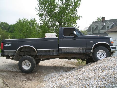 1979 Ford F-150 - Side view of a black Ford F-150 pickup truck with a toolbox in the bed.