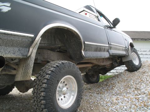 1979 Ford F-150 - A black pickup truck with prominent off-road tires navigates a steep gravel slope.
