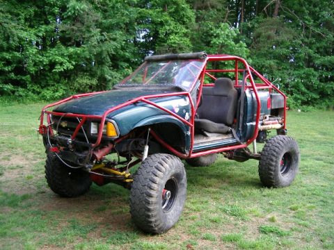 1985 Ford Bronco - This heavily modified off-road vehicle features a custom roll cage and large tires, suggesting it is not a stock 1985 Ford Bronco.