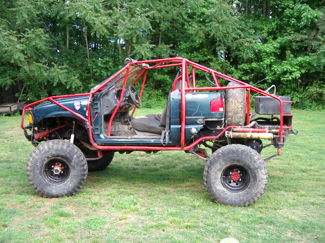 Off-road vehicle with red roll cage, large tires, and no doors