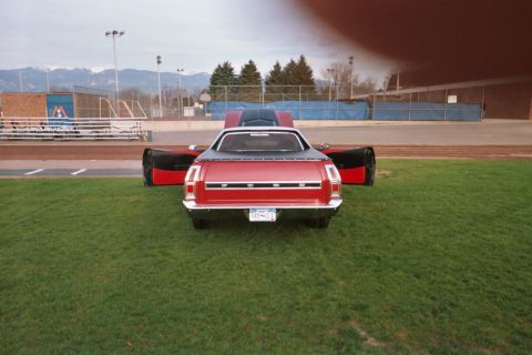 1972 Ford Ranchero - Rear view of a red 1972 Ford Ranchero with its hood and doors open at a car show.