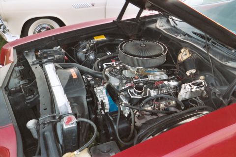 1972 Ford Ranchero - The engine bay of a red 1972 Ford Ranchero is open, revealing its V8 engine and chrome air cleaner.